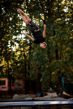 man jumping energetically and performs trick upside down in the airの写真素材