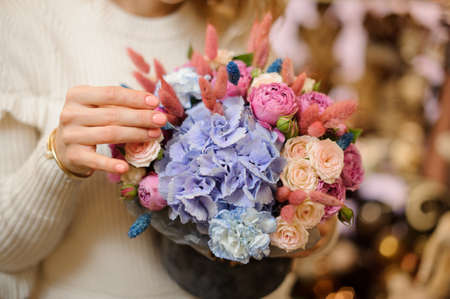 Close-up of beautiful bouquet with flowers of hydrangea rose and peony in female hands.の写真素材