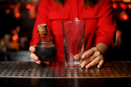close-up of transparent glass and crystal decanter with wine in womans hand
