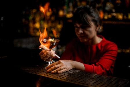 great view on glass on bar counter which lady barman masterfully sprinkles and sets fireの写真素材
