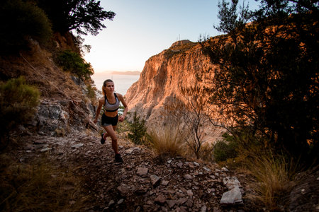 Young active woman climbs up trail among mountains in Turkey