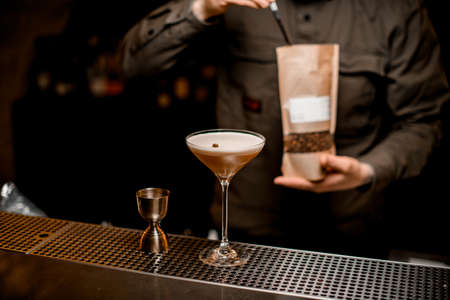 view of beautiful glass with frothy espresso martini cocktail decorated with coffee beanの写真素材