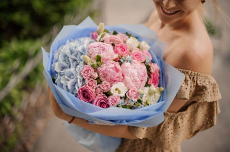 gorgeous large bouquet of multi-colored flowers in the hands of smiling womanの写真素材