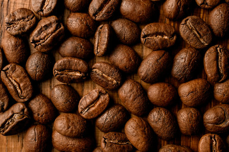 Close-up top view of dark roasted coffee beans on table.