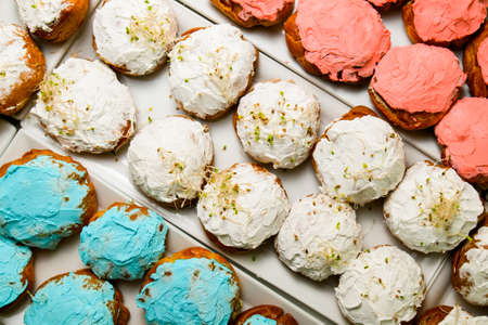 Top view of delicious french choux pastry cakes with different colorful creamの写真素材