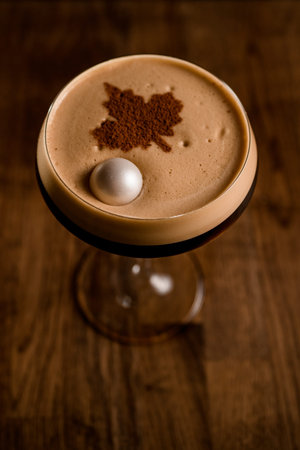 top view of glass of frothy drink decorated by cocoa powder and small marshmallow