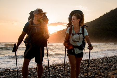 young couple tourists look at each other against the background of sunset