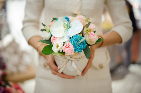 Close-up of colorful flower arrangement in hands of woman