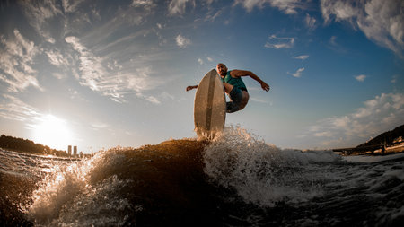 athlete effectively jumping over the wave on the wakeboarding boardの写真素材