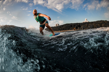 athlete wakesurfer rides the waves on the background of the beautiful blue skyの写真素材