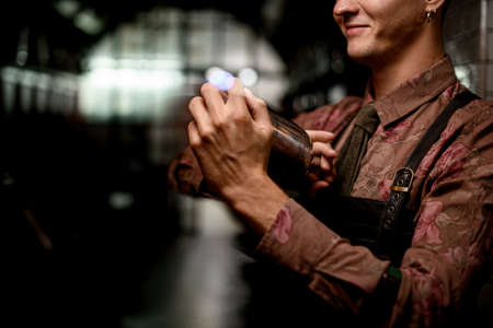 male hands of bartender holds steel shaker and shake itの写真素材