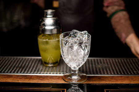 Beautiful transparent crystal glass with crushed ice on the bar counter.の写真素材