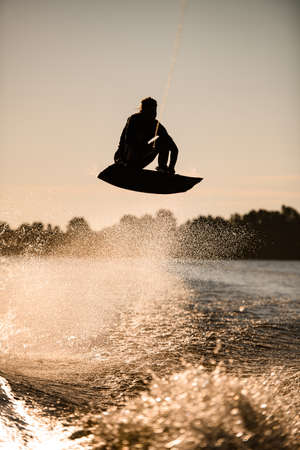 wakeboarder athlete man jumping high making tricks in the airの写真素材