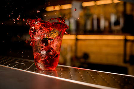 beautiful close-up view of glass of cocktail with splashes of liquid scatter aroundの写真素材