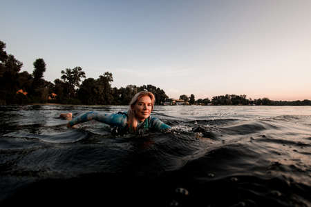 view of beautiful face of attractive young woman floating on waterの写真素材