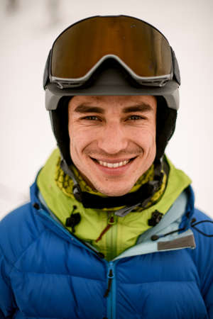 Head shot of smiling man skier wearing ski helmet with gogglesの写真素材
