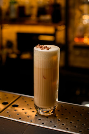 tall glass with whipped creamy cocktail drink on the bar counter