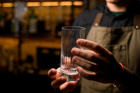 close-up shot of a male hand holding an empty drinking glassの写真素材