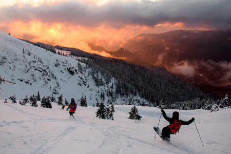 Wonderful picturesque scene of mountain landscape and freeride skiers descends from slopeの写真素材