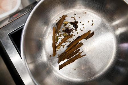 close-up top view of bowl with cinnamon sticks, anise and spices