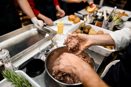 male chef hand holds a piece of minced meatの写真素材