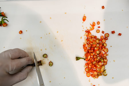 Top view of sliced red hot chili pepper on white cutting boardの写真素材