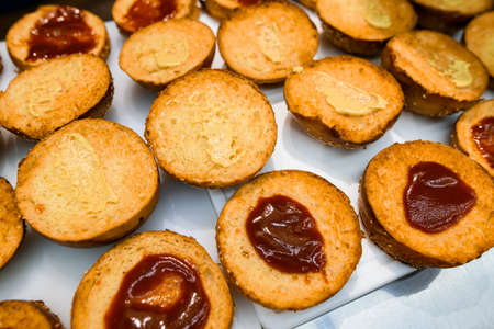 Close-up of a row of toasted halves of hamburger buns anointed with ketchupの写真素材