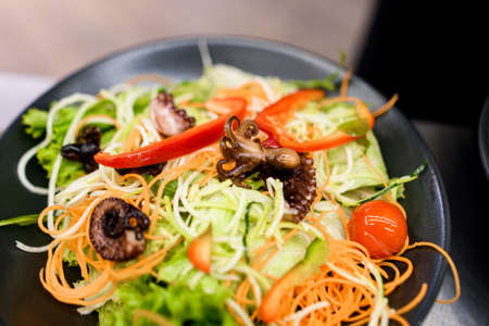 Close-up of plate with delicious salad with vegetables greens and lettuce and seafoodの写真素材