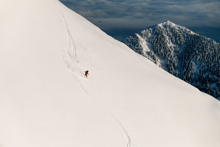 Wonderful view of mountain slope and skier sliding down on it. Freeride skiing concept