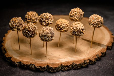 great view on group of chocolate candy pops on sticks on wooden plateの写真素材