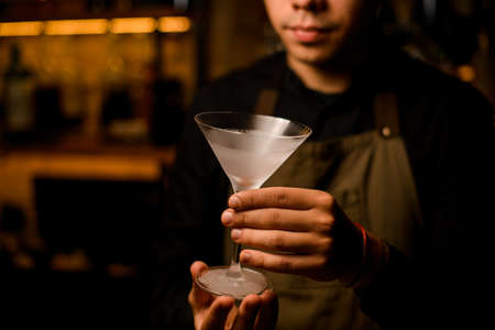 beautiful empty frosted martini wine glass in male handsの写真素材
