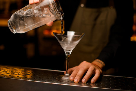 martini glass on in which a cocktail is poured from a mixing cupの写真素材