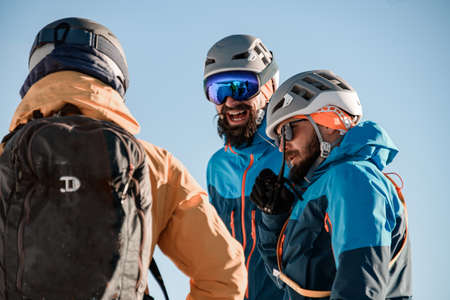 Close-up view on group of men skiers in sunglasses and a ski helmetsの写真素材