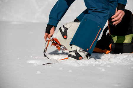 Close-up of leg of man wearing climbing crampons over mountaineering shoes for walking through glacier.の写真素材