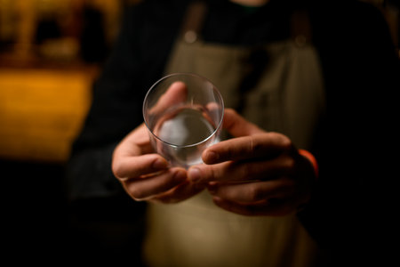 hands of bartender accurate hold cocktail glass. Focus on the fingersの写真素材