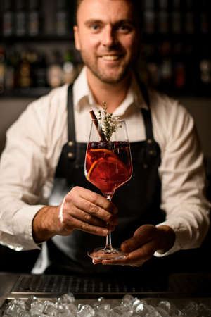 beautiful glass with delicious exclusive cocktail in the hands of a male bartenderの写真素材