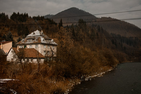 UKRAINE, CARPATHIANS - FEBRUARY 24, 2021: beautiful view of the house by the river.のeditorial素材
