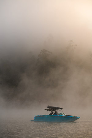 wonderful view of bright motorboat on water covered with fog.