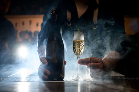 amazing view of champagne glass with drink and bottle at smoked barの写真素材