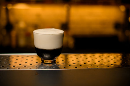 glass of signature cocktail with whipped cream foam on bar. Copy spaceの写真素材