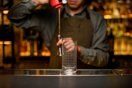 Front view of clean transparent empty glass with grid pattern on bar. Blurred backgroundの写真素材