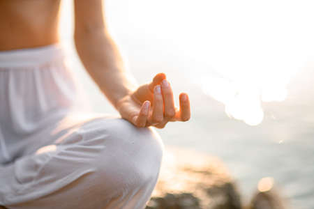 close-up of hands, gyan mudra and lotus position. Fragment of woman practicing yogaの写真素材