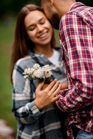 selective focus of wildflowers in the hand of man which he gives to smiling womanの写真素材