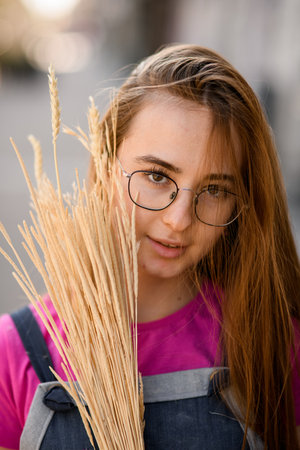 Close-up portrait of woman with dry grass branches near face.の写真素材