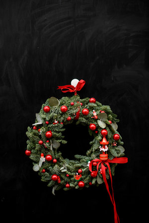 beautiful Christmas fir wreath with red balls and red ribbon on dark backgroundの写真素材
