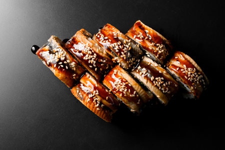 Top view on Philadelphia sushi rolls with rice, salmon, eel, cucumber, tobiko caviar, cheese, soya sauce and sesameの写真素材