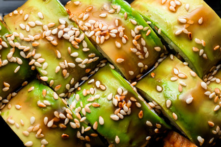 Close-up top view of green dragon sushi rolls with avocado and sesame seeds. Cropped photoの写真素材