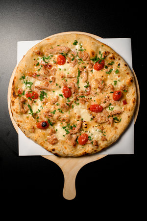 top view on pizza with cherry tomatoes and chicken garnished by green