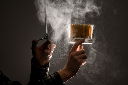 great view on vintage brush and scissors in male hands and talcum powder in the air.の写真素材