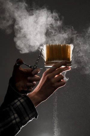 wonderful view on vintage brush and scissors in male hands and talcum powder in the air.の写真素材